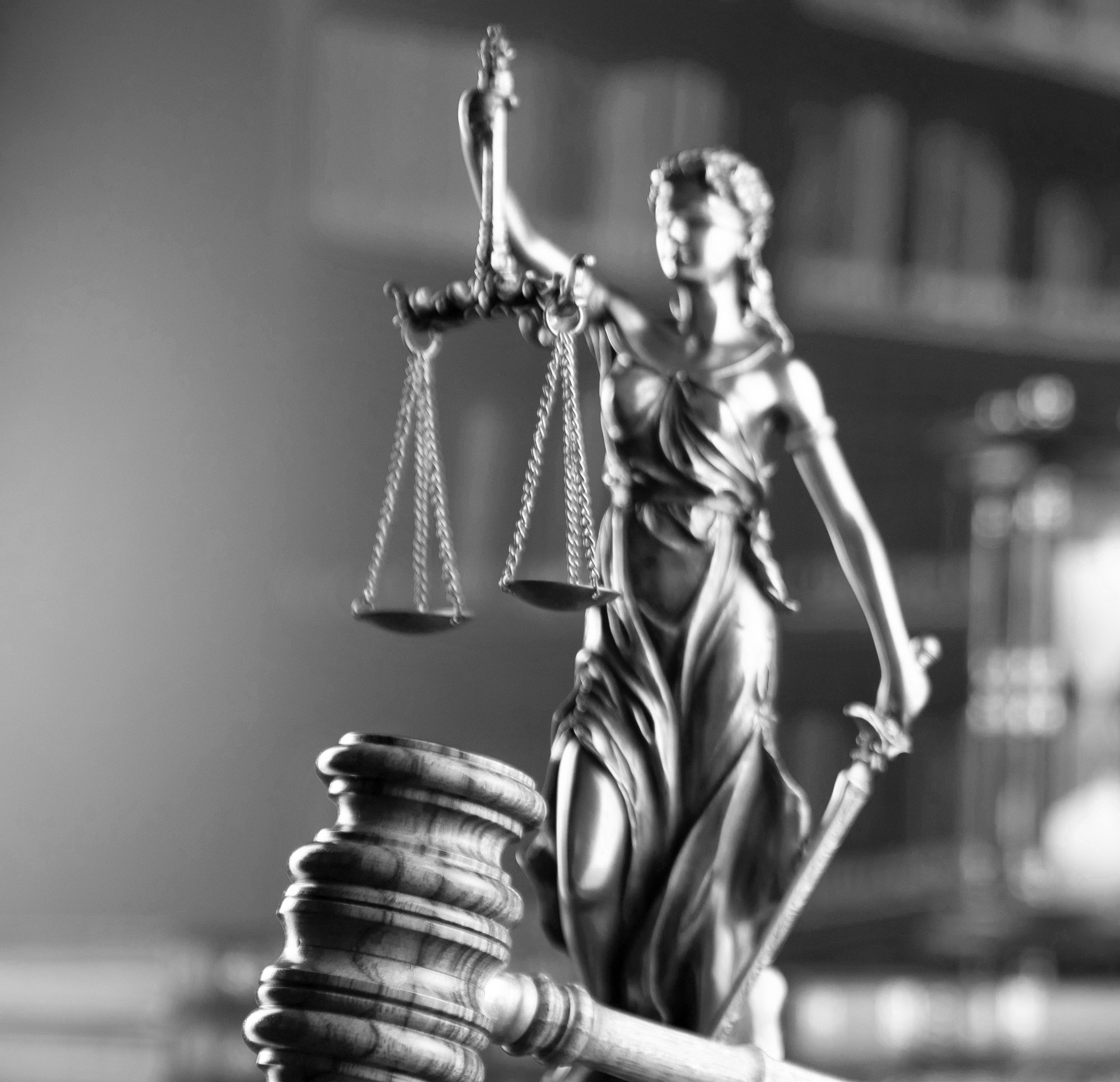 Black and white image of a statue holding the scales of justice